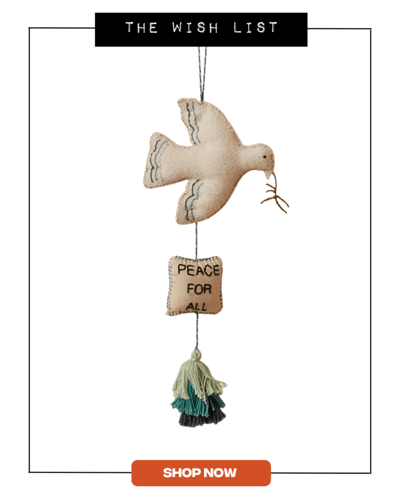 Wall hanging featuring a white bird and cushion that reads 'Peace for All'