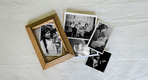 Multiple family photographs laid out on a linen spread.